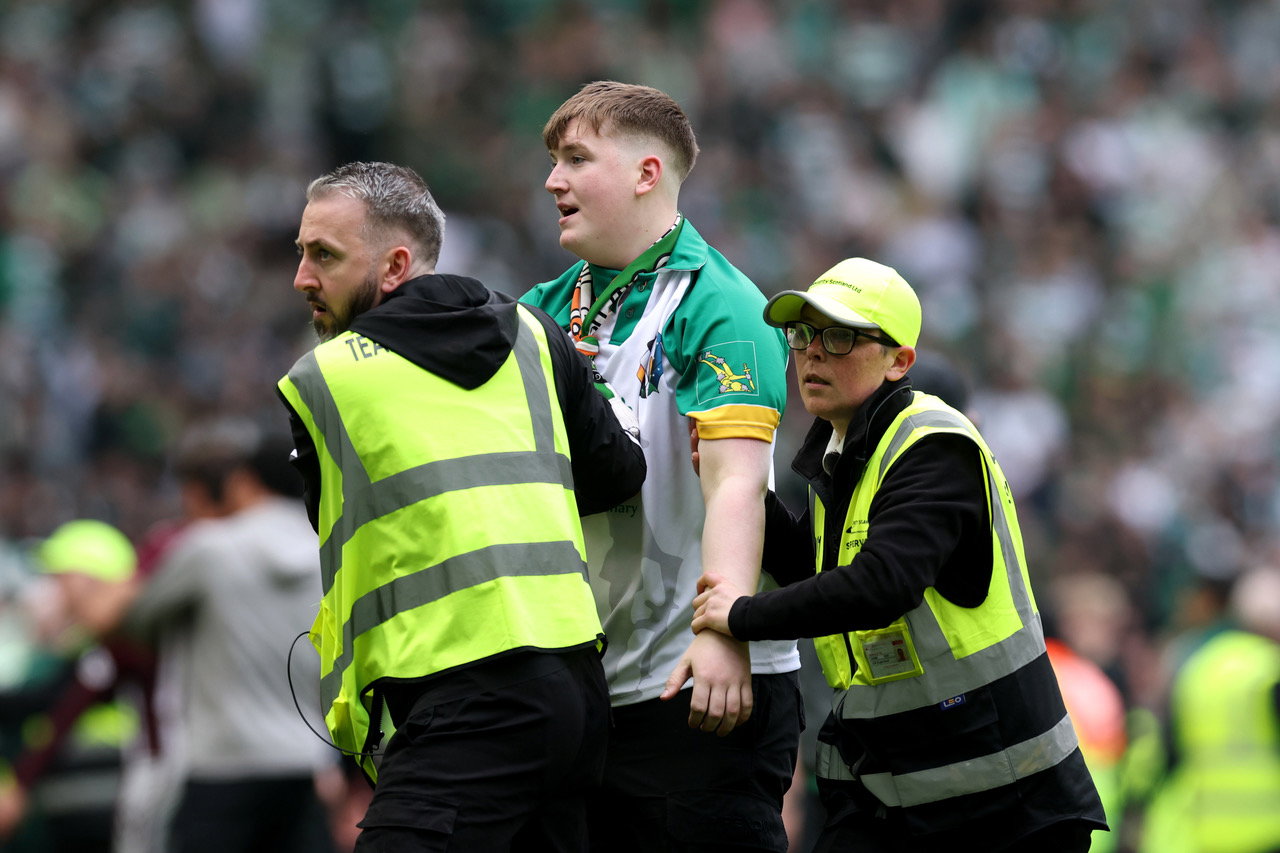 A Celtic fan is apprehended by security staff
