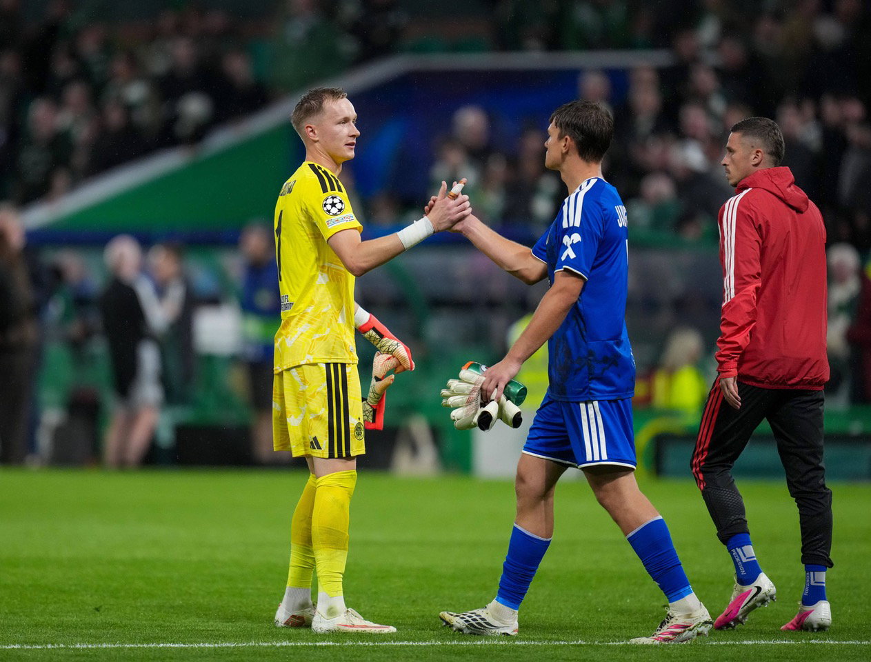Celtic goalkeeper Viljami Sinisalo shakes hands with LASK goalkeeper Lukas Jungwirth