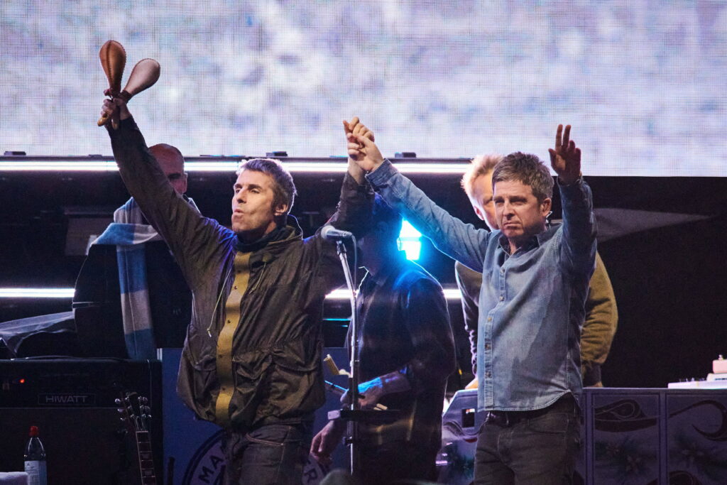 Liam Gallagher left and Noel Gallagher of Oasis walk onstage